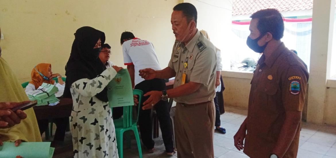 Suryadi staf BPN Lamsel didampingi Kades Suak, Juli Wahyudin secara simbolis menyerahkan Sertifikat kepada ibu Sur