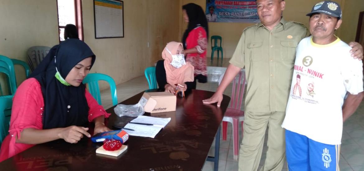 Kades Rantau Minyak Wartono saat melihat lihat berlangsungnya penyaluran sembako kepada warga