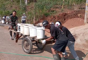Satgas TMMD dan Warga Kompak Dorong Gerobak di Jalan Menurun